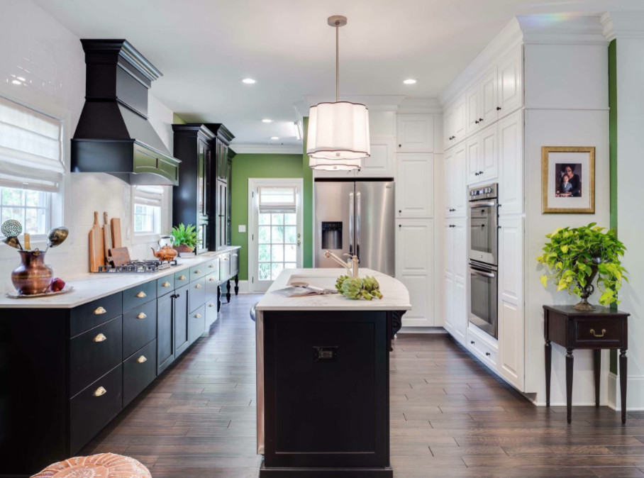 Mid-sized transitional single-wall dark wood floor and brown floor enclosed kitchen photo in DC Metro with marble countertops, white backsplash, stainless steel appliances, an island, flat-panel cabinets, black cabinets, subway tile backsplash, an undermount sink and white countertops