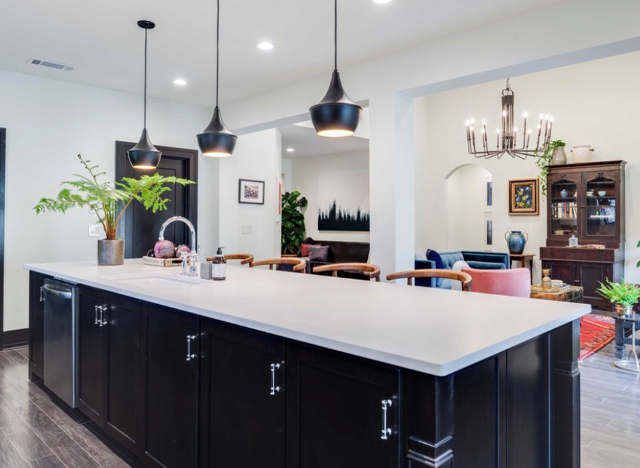Large trendy single-wall light wood floor and beige floor eat-in kitchen photo in DC Metro with an undermount sink, shaker cabinets, black cabinets, solid surface countertops, stainless steel appliances and an island