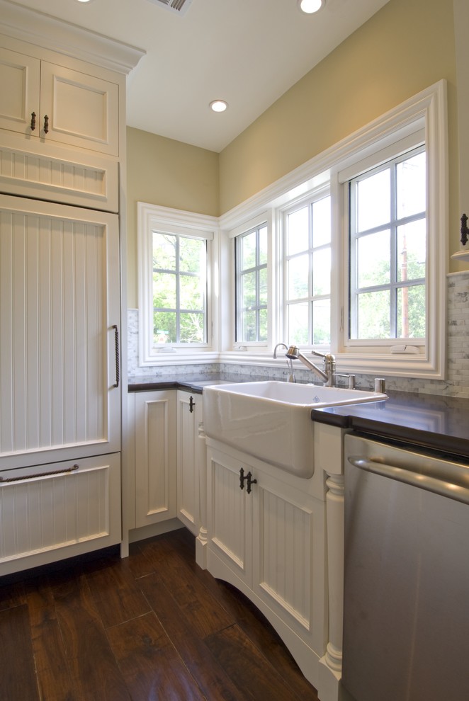 Elegant kitchen photo in San Francisco with paneled appliances, a farmhouse sink, recessed-panel cabinets, white cabinets, quartz countertops, white backsplash and stone tile backsplash