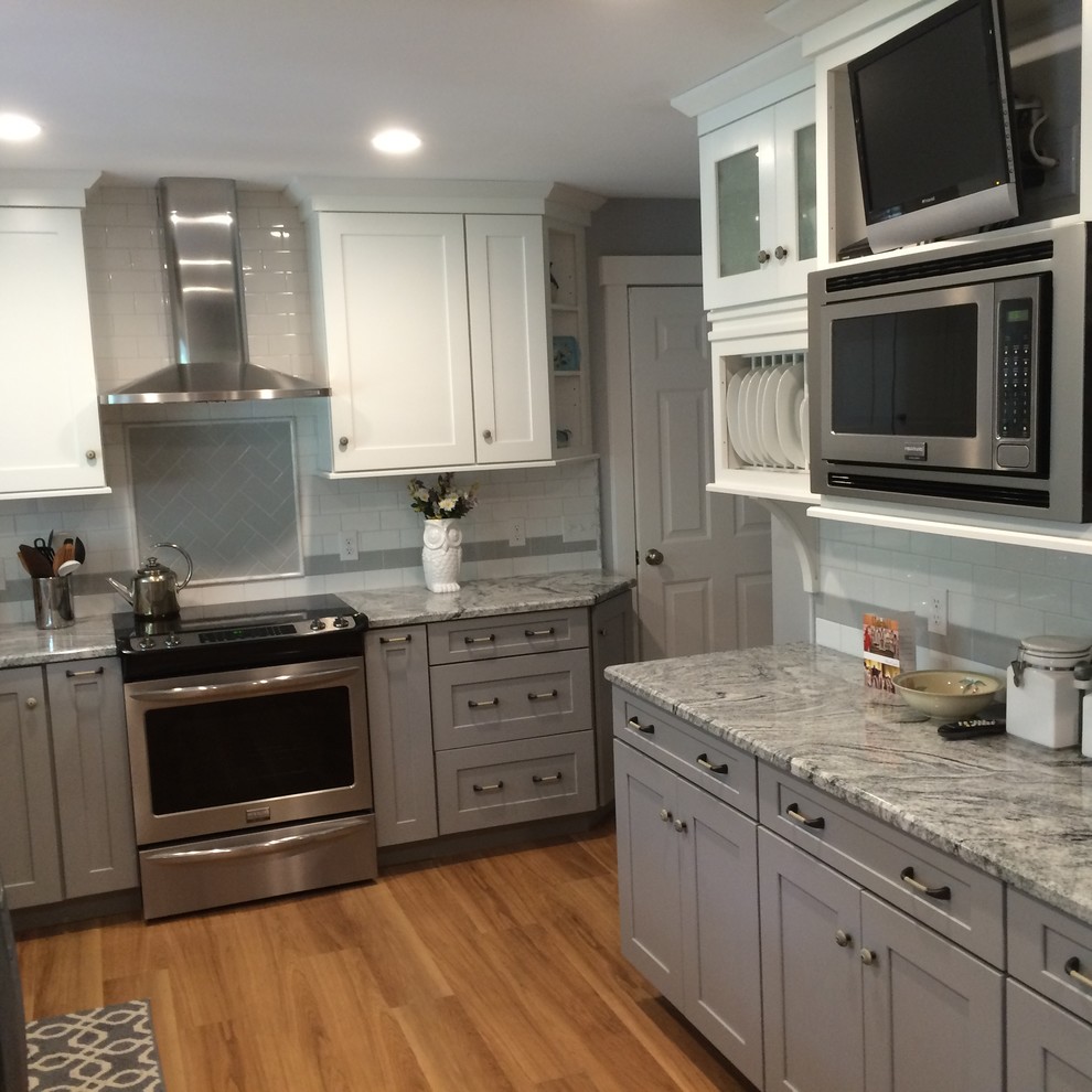 Bild på ett mellanstort funkis u-kök, med en rustik diskho, skåp i shakerstil, grå skåp, granitbänkskiva, vitt stänkskydd, stänkskydd i tunnelbanekakel, rostfria vitvaror och ljust trägolv