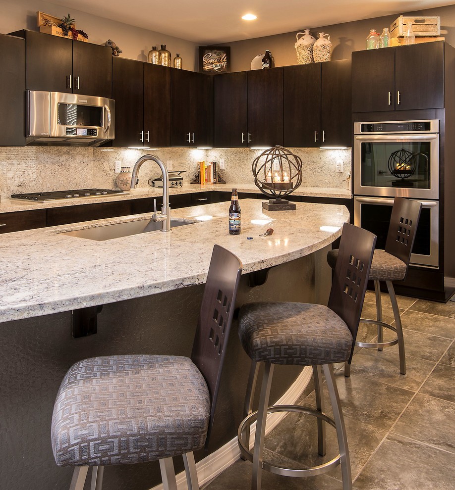 Example of a huge trendy u-shaped ceramic tile open concept kitchen design in Phoenix with an undermount sink, flat-panel cabinets, dark wood cabinets, granite countertops, beige backsplash, stone slab backsplash and stainless steel appliances