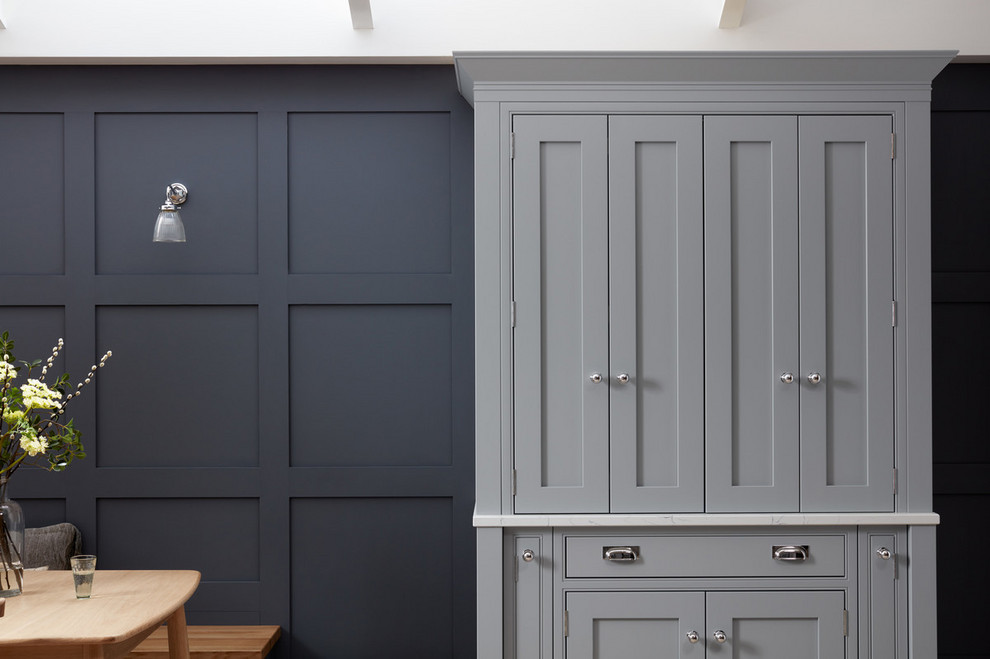 ロンドンにある高級な広いトランジショナルスタイルのおしゃれなキッチン (シェーカースタイル扉のキャビネット、グレーのキャビネット、御影石カウンター、白いキッチンパネル、淡色無垢フローリング、茶色い床) の写真