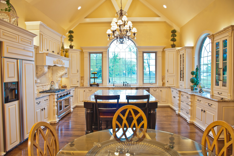 Example of a classic u-shaped eat-in kitchen design in Nashville with raised-panel cabinets, beige cabinets and paneled appliances