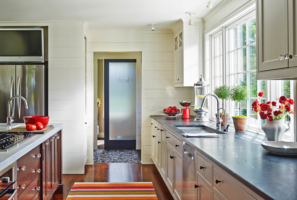 Bild på ett vintage kök, med en undermonterad diskho, luckor med profilerade fronter, vita skåp, bänkskiva i betong, rostfria vitvaror, mellanmörkt trägolv och en köksö