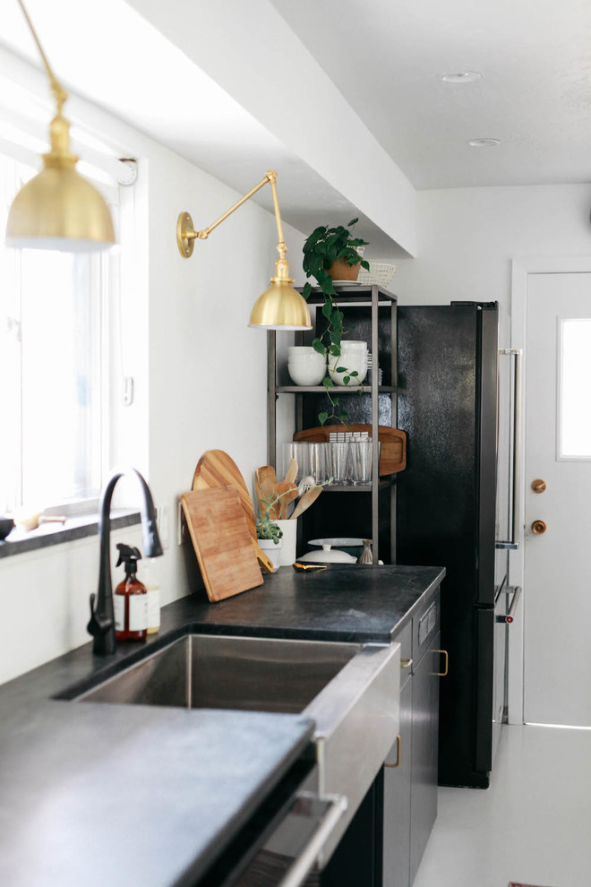Inspiration for a medium sized scandi galley kitchen/diner in Boise with a belfast sink, flat-panel cabinets, grey cabinets, soapstone worktops, white splashback, window splashback, black appliances, painted wood flooring, a breakfast bar and white floors.