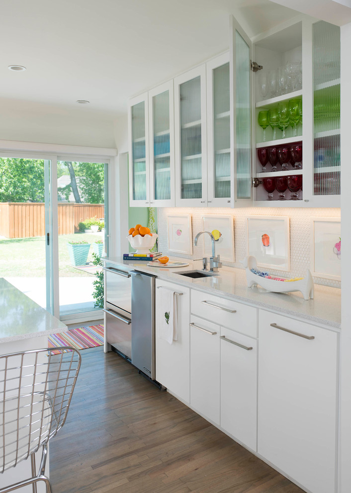 Inspiration for a mid-sized contemporary u-shaped light wood floor and beige floor eat-in kitchen remodel in Dallas with a single-bowl sink, white cabinets, quartzite countertops, white backsplash, porcelain backsplash, stainless steel appliances, an island, white countertops and glass-front cabinets