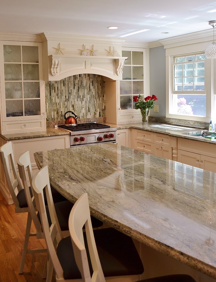 Mid-sized transitional l-shaped medium tone wood floor eat-in kitchen photo in Boston with an undermount sink, flat-panel cabinets, green cabinets, granite countertops, green backsplash, glass tile backsplash, paneled appliances and an island