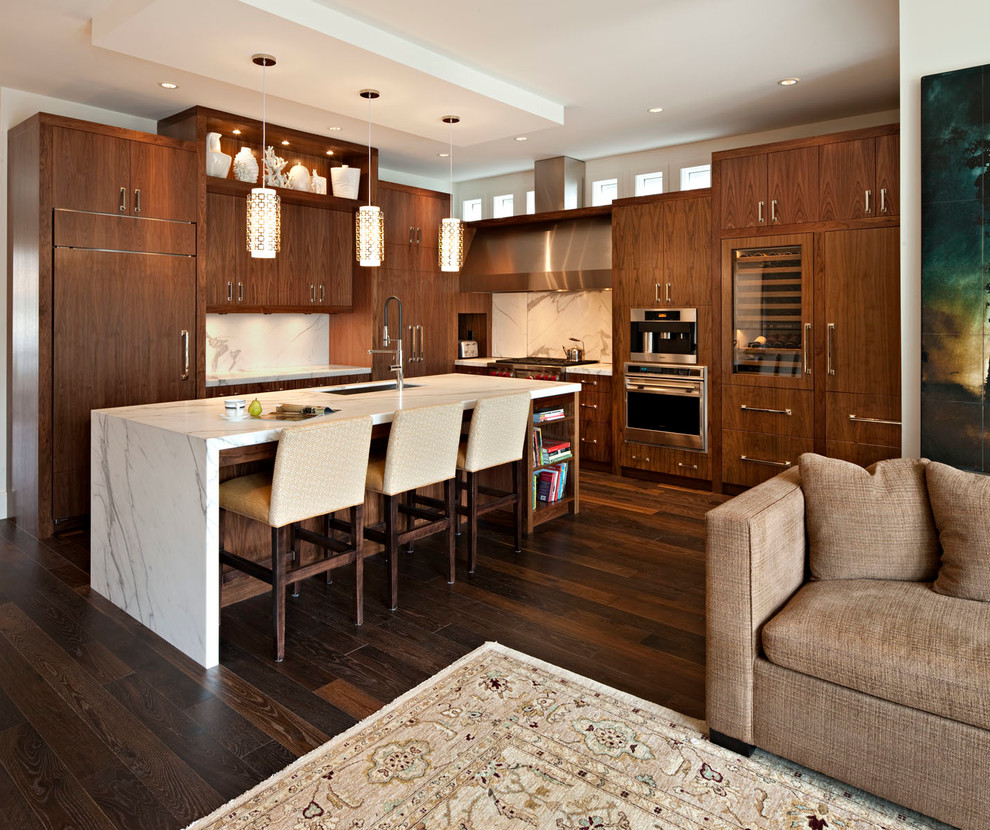 Immagine di una cucina classica con lavello sottopiano, ante lisce, ante in legno bruno, paraspruzzi bianco e elettrodomestici da incasso