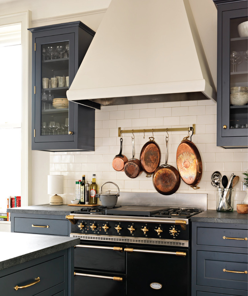 Inspiration for a mid-sized transitional u-shaped medium tone wood floor and brown floor eat-in kitchen remodel in New York with a farmhouse sink, shaker cabinets, blue cabinets, soapstone countertops, white backsplash, ceramic backsplash, colored appliances and an island