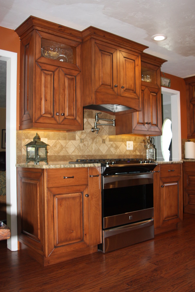 Bild på ett mellanstort funkis kök och matrum, med luckor med upphöjd panel, skåp i mellenmörkt trä, granitbänkskiva, beige stänkskydd, stänkskydd i keramik, rostfria vitvaror och mellanmörkt trägolv