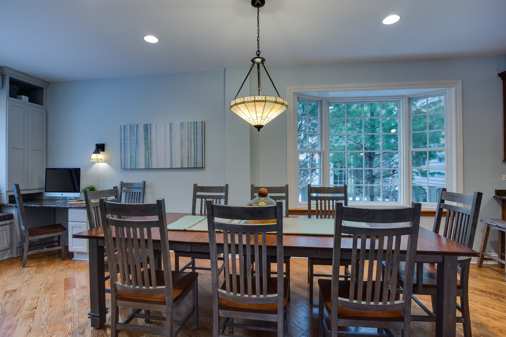 Immagine di una sala da pranzo aperta verso il soggiorno stile americano di medie dimensioni con parquet chiaro