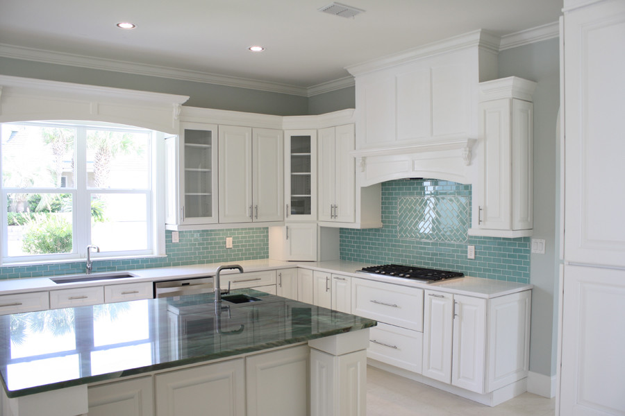 Foto de cocina actual grande con puertas de armario blancas, salpicadero azul, electrodomésticos de acero inoxidable y una isla