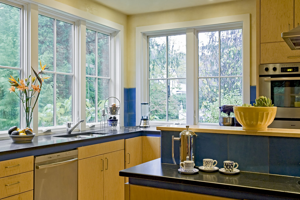 Moderne Küche mit Küchengeräten aus Edelstahl, Doppelwaschbecken, flächenbündigen Schrankfronten und hellbraunen Holzschränken in Burlington