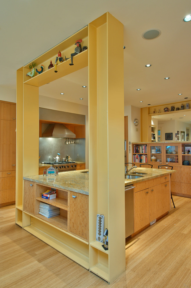 Cette image montre une cuisine minimaliste en bois brun avec un évier encastré, un placard à porte plane, une crédence métallisée, une crédence en dalle métallique et un électroménager en acier inoxydable.