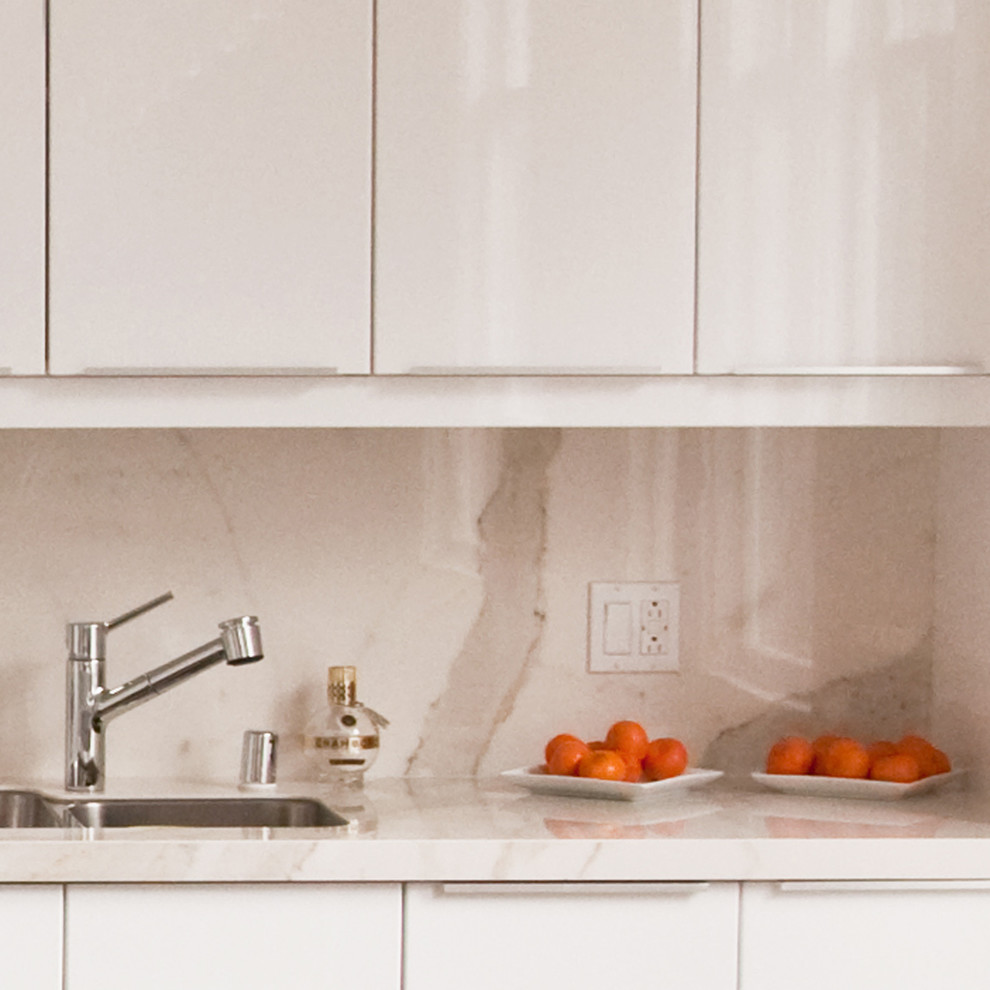 Esempio di una piccola cucina minimalista con lavello sottopiano, ante lisce, ante bianche, top in marmo, paraspruzzi bianco, paraspruzzi in lastra di pietra, elettrodomestici in acciaio inossidabile e pavimento in gres porcellanato