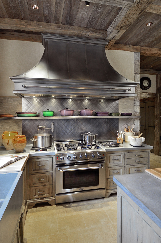Exempel på ett kök, med en rustik diskho, luckor med infälld panel, bänkskiva i betong, grått stänkskydd, stänkskydd i keramik, rostfria vitvaror, kalkstensgolv och en köksö