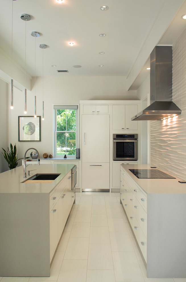 This is an example of a contemporary galley kitchen in Charleston with a submerged sink, flat-panel cabinets, white cabinets, white splashback and an island.