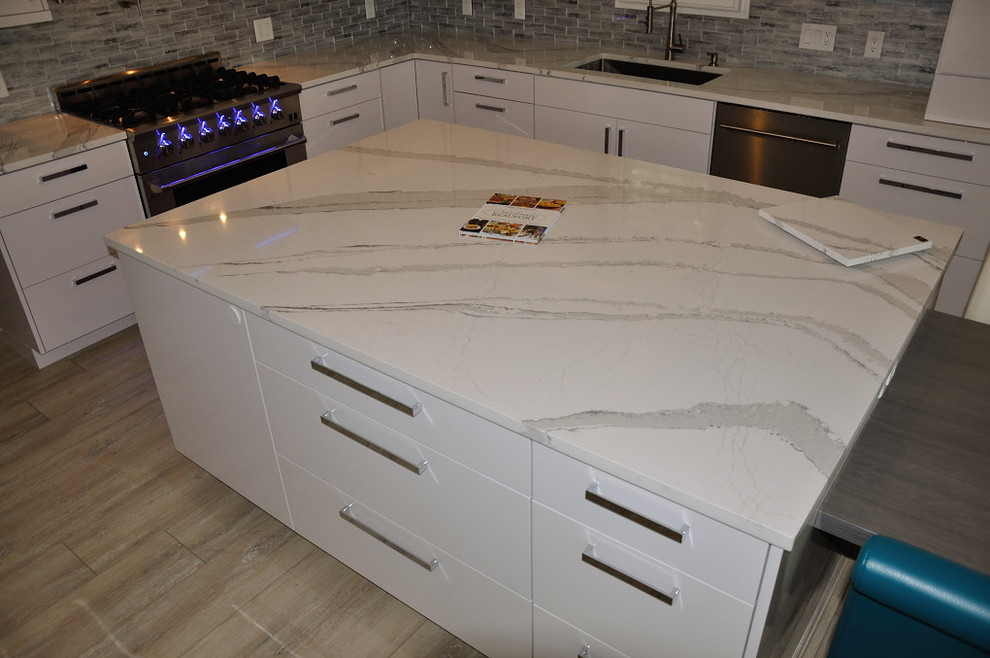 Esempio di un cucina con isola centrale design con lavello sottopiano, top in quarzo composito e paraspruzzi con piastrelle in ceramica