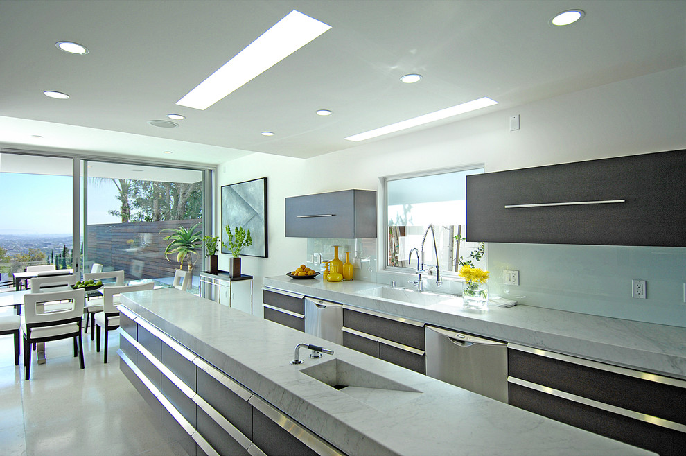 Exempel på ett litet modernt kök, med en köksö, släta luckor, grå skåp, marmorbänkskiva, vitt stänkskydd, glaspanel som stänkskydd, rostfria vitvaror och en integrerad diskho