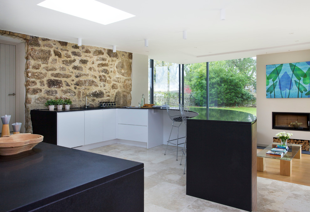 Imagen de cocina contemporánea abierta con península y pared de piedra