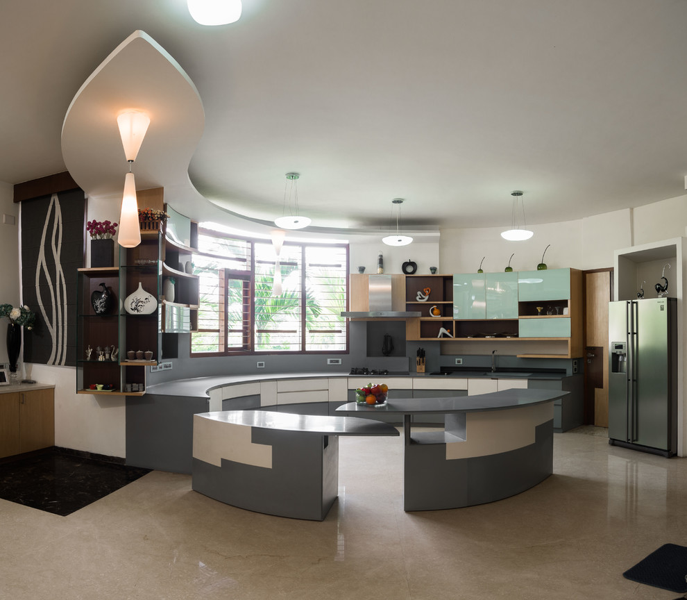 バンガロールにあるコンテンポラリースタイルのおしゃれなマルチアイランドキッチン (フラットパネル扉のキャビネット、青いキャビネット、グレーのキッチンパネル、シルバーの調理設備、ベージュの床、グレーのキッチンカウンター) の写真