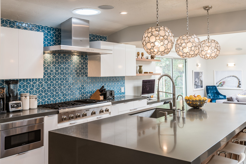 Bild på ett funkis kök, med blått stänkskydd, stänkskydd i keramik och en köksö
