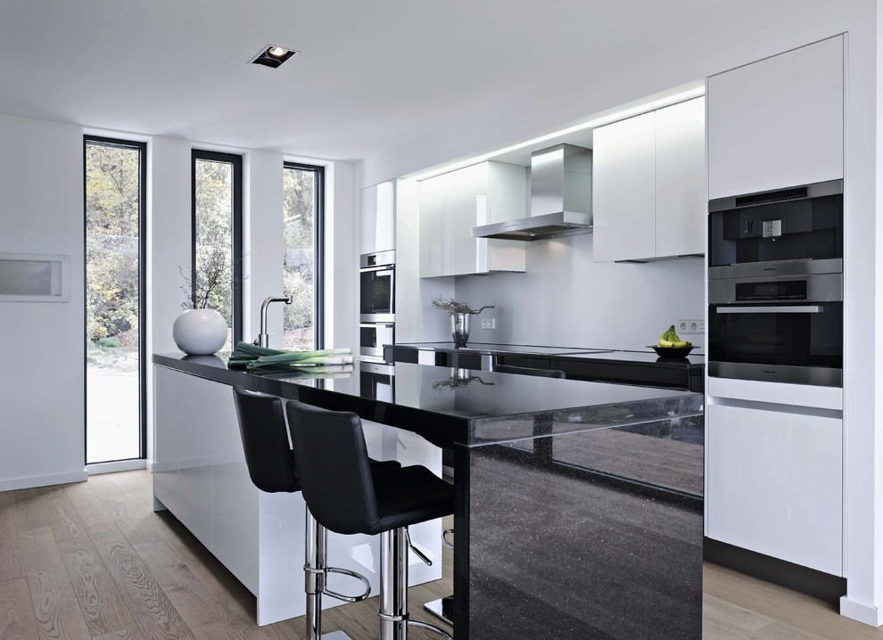 Foto de cocina contemporánea con armarios con paneles lisos y con blanco y negro