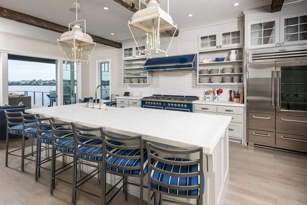 Inspiration for a coastal light wood floor and beige floor kitchen remodel in Boston with a farmhouse sink, gray cabinets, white backsplash, subway tile backsplash, stainless steel appliances, an island and white countertops