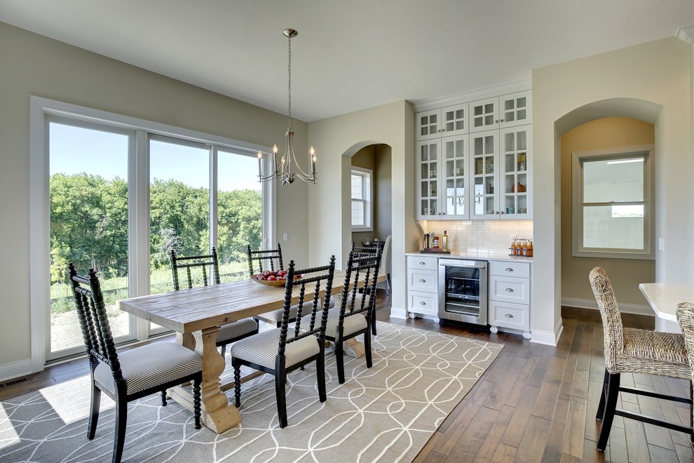 Eat-in kitchen - large transitional u-shaped medium tone wood floor eat-in kitchen idea in Minneapolis with a farmhouse sink, glass-front cabinets, white cabinets, marble countertops, white backsplash, subway tile backsplash, stainless steel appliances and an island