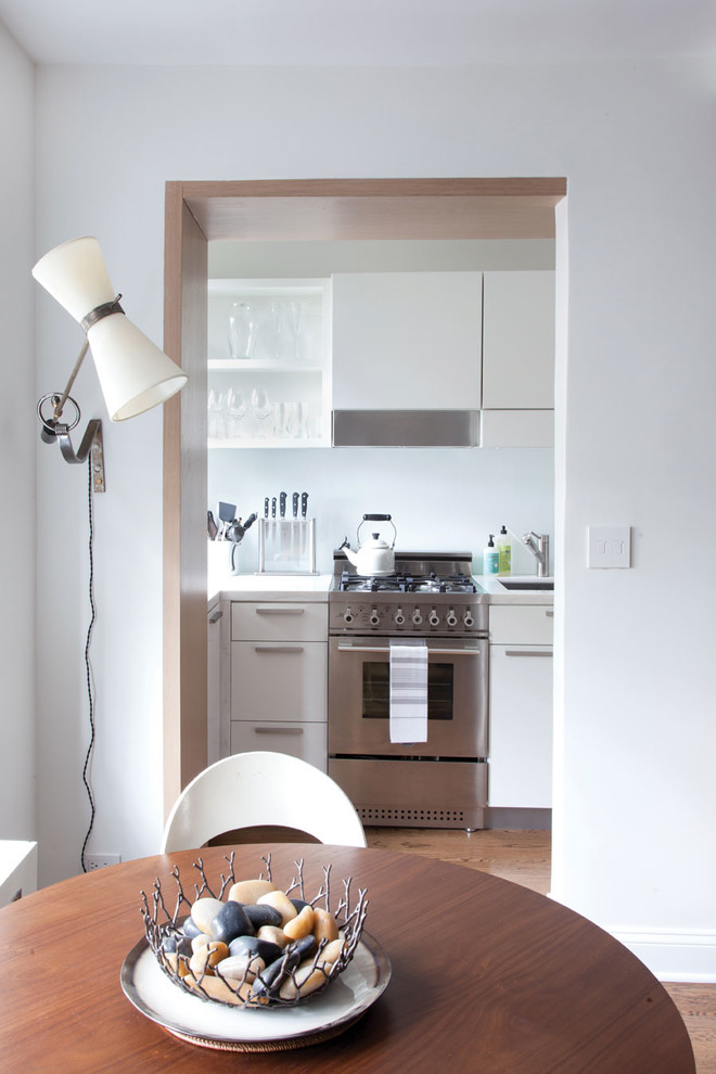 Geschlossene Moderne Küche mit offenen Schränken, weißen Schränken und Küchengeräten aus Edelstahl in New York
