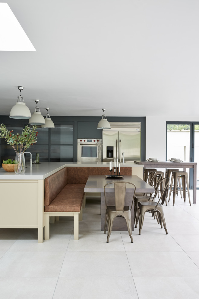 Inspiration for a large contemporary l-shaped kitchen/diner in London with flat-panel cabinets, blue cabinets, composite countertops, metallic splashback, metal splashback, stainless steel appliances, multiple islands and white worktops.