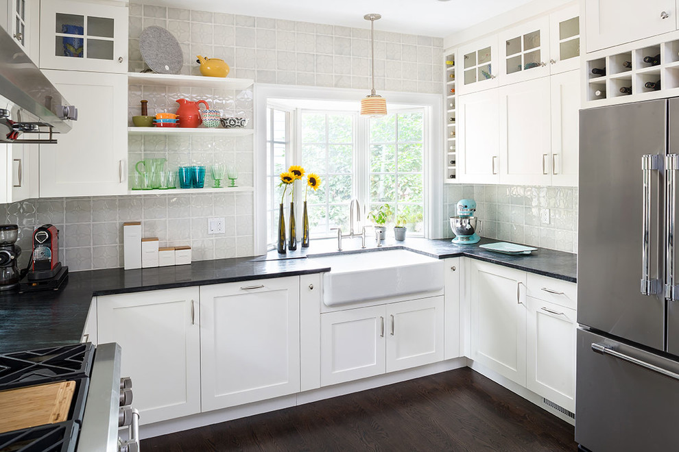 Klassische Küche mit Landhausspüle, Schrankfronten im Shaker-Stil, weißen Schränken, Küchenrückwand in Grau und dunklem Holzboden in New York