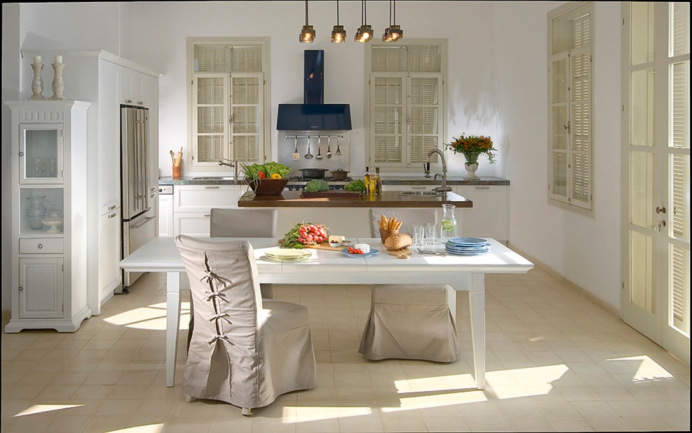 Immagine di una cucina stile shabby con ante bianche, elettrodomestici in acciaio inossidabile e ante con riquadro incassato