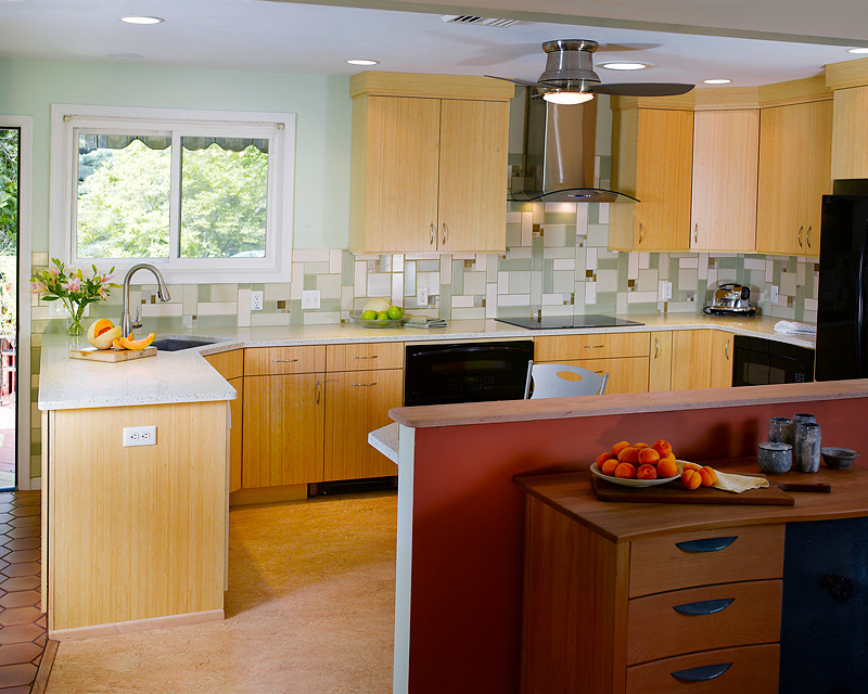 Exempel på ett mellanstort modernt kök, med en undermonterad diskho, släta luckor, skåp i ljust trä, bänkskiva i återvunnet glas, svarta vitvaror, linoleumgolv, grönt stänkskydd, stänkskydd i glaskakel och en halv köksö
