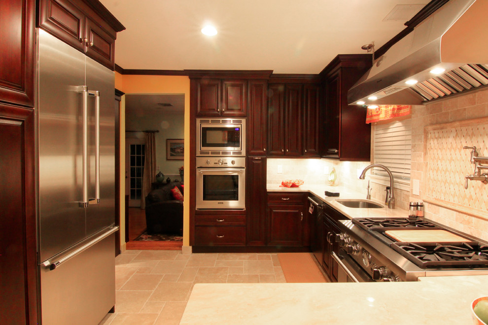 Exempel på ett klassiskt u-kök, med skåp i mörkt trä, rostfria vitvaror, klinkergolv i keramik och beiget golv