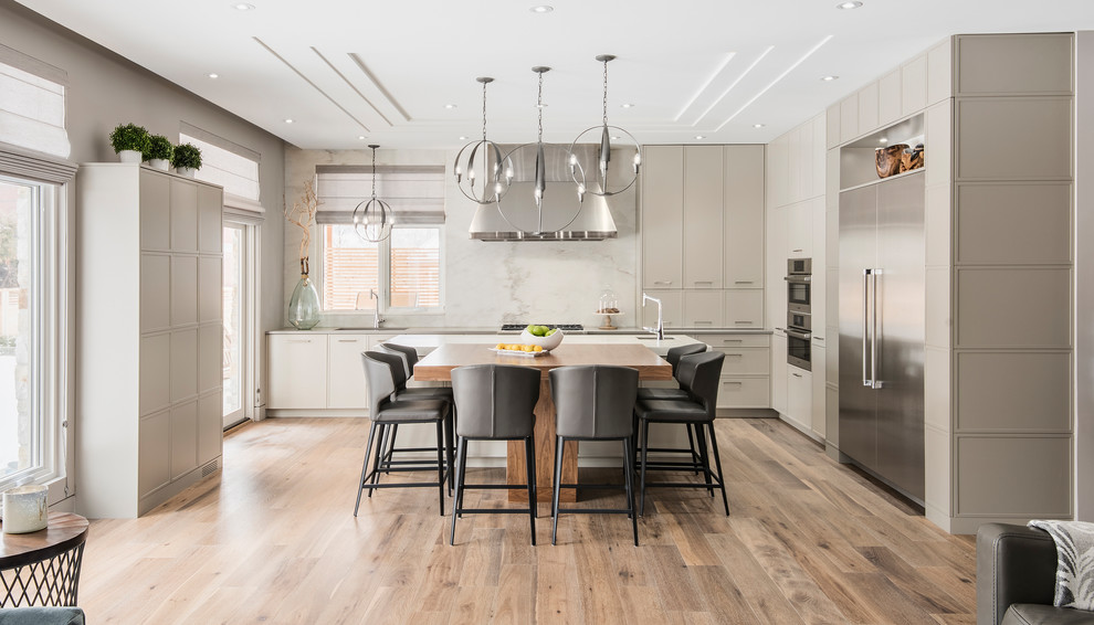 Design ideas for a contemporary l-shaped kitchen in Ottawa with flat-panel cabinets, grey cabinets, grey splashback, stainless steel appliances, medium hardwood flooring, an island and brown floors.