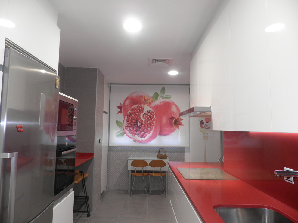 This is an example of a medium sized traditional galley kitchen/diner in Other with a submerged sink, flat-panel cabinets, white cabinets, quartz worktops, red splashback, stone slab splashback, white appliances and porcelain flooring.