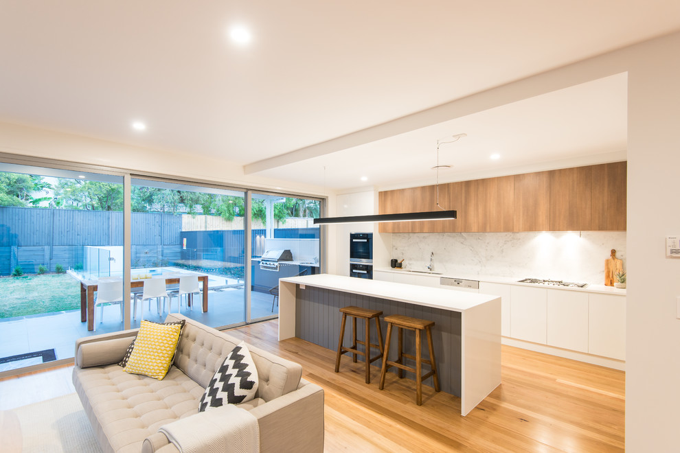Moderne Küche mit Vorratsschrank, Unterbauwaschbecken, Marmor-Arbeitsplatte, Küchenrückwand in Grau, Rückwand aus Marmor, Küchengeräten aus Edelstahl, braunem Holzboden und Kücheninsel in Brisbane