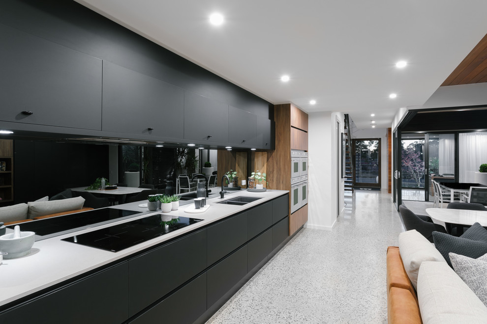 Источник вдохновения для домашнего уюта: прямая кухня-гостиная в современном стиле с черными фасадами, черным фартуком и белой столешницей без острова