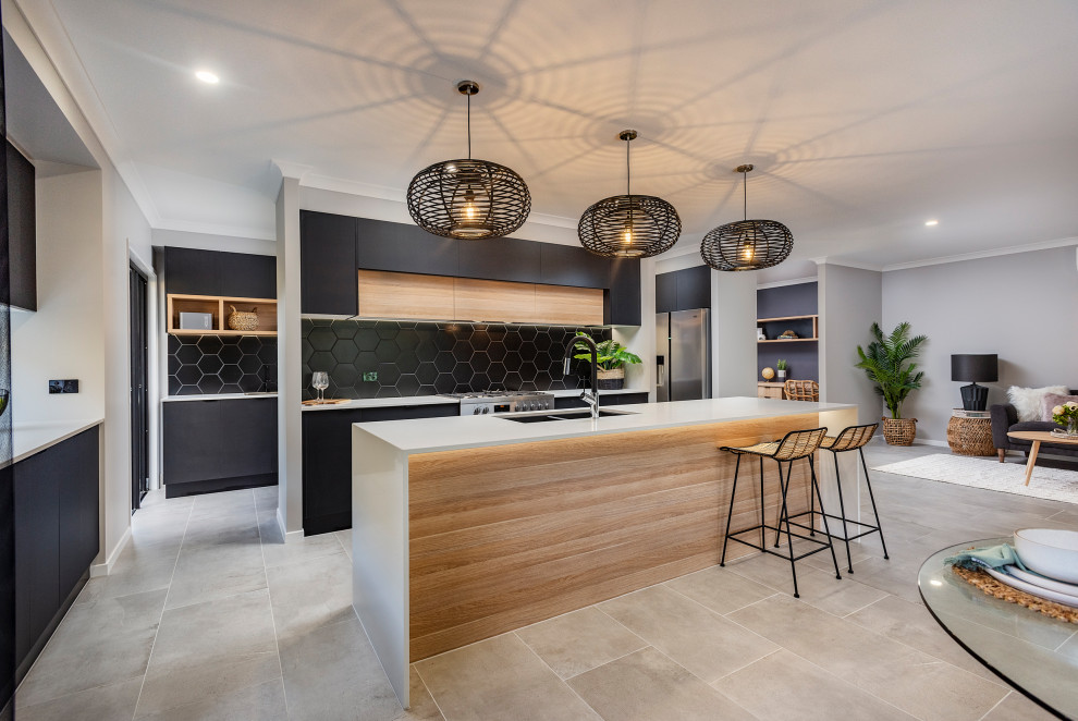 Стильный дизайн: параллельная кухня-гостиная среднего размера в современном стиле с врезной мойкой, черным фартуком, островом и серым полом - последний тренд