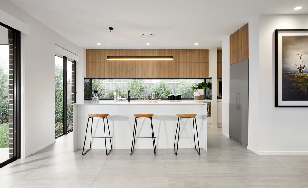 Offene, Zweizeilige Moderne Küche mit flächenbündigen Schrankfronten, hellbraunen Holzschränken, Rückwand-Fenster, Küchengeräten aus Edelstahl, Kücheninsel und grauem Boden in Sydney