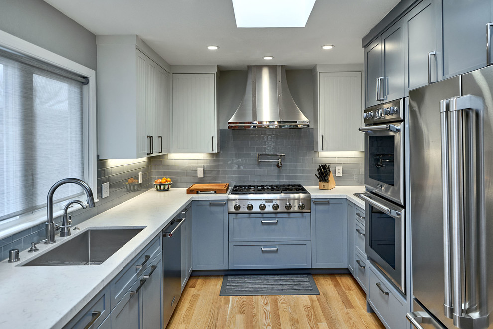Design ideas for a medium sized classic u-shaped kitchen in San Francisco with a submerged sink, blue cabinets, marble worktops, grey splashback, stainless steel appliances, no island, white worktops, shaker cabinets, metro tiled splashback, light hardwood flooring and beige floors.
