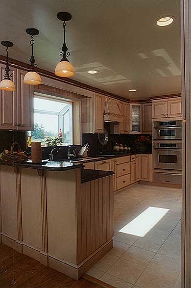 Idéer för ett klassiskt u-kök, med luckor med upphöjd panel, skåp i ljust trä, bänkskiva i kvarts, svart stänkskydd och rostfria vitvaror