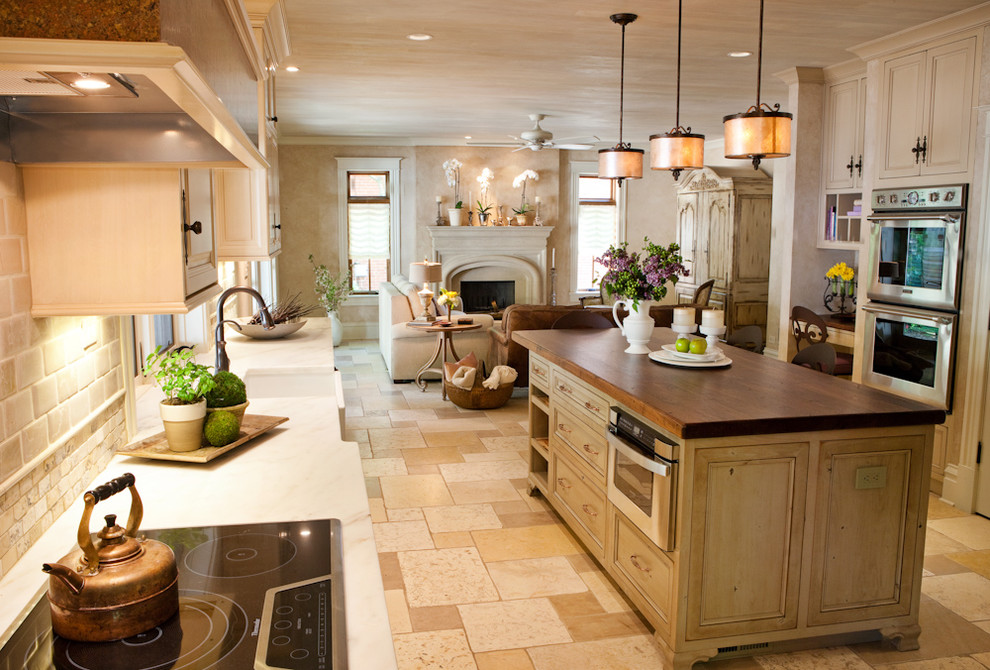 Example of a large classic u-shaped ceramic tile open concept kitchen design in St Louis with a farmhouse sink, recessed-panel cabinets, distressed cabinets, quartz countertops, beige backsplash, subway tile backsplash, stainless steel appliances and an island