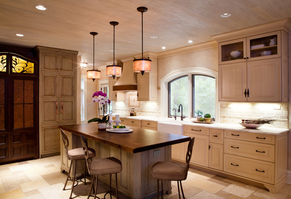 Exempel på ett stort klassiskt kök, med en rustik diskho, luckor med infälld panel, skåp i slitet trä, bänkskiva i kvarts, beige stänkskydd, stänkskydd i tunnelbanekakel, rostfria vitvaror, klinkergolv i keramik och en köksö