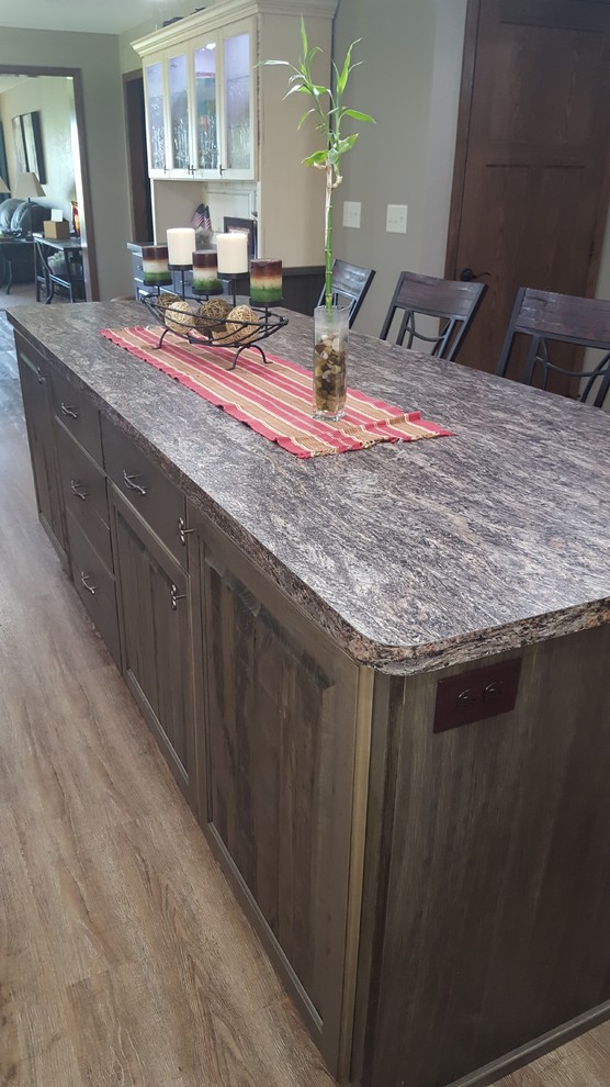 Example of a mid-sized mountain style l-shaped vinyl floor eat-in kitchen design in Minneapolis with a double-bowl sink, raised-panel cabinets, distressed cabinets, laminate countertops, gray backsplash, stainless steel appliances and an island