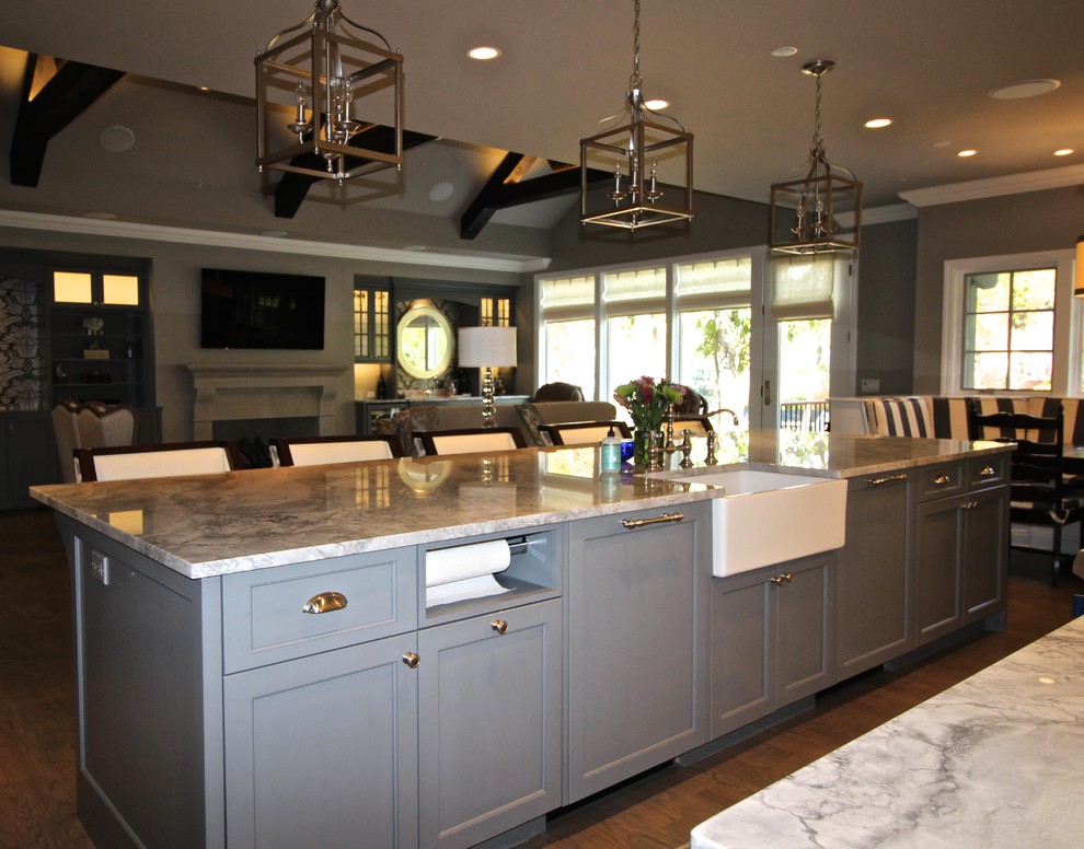 Example of a large minimalist single-wall medium tone wood floor eat-in kitchen design in Omaha with a farmhouse sink, flat-panel cabinets, white cabinets, granite countertops, white backsplash, ceramic backsplash, stainless steel appliances and an island