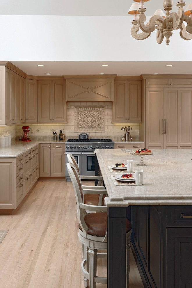 Photo of an expansive classic l-shaped kitchen/diner in DC Metro with a submerged sink, raised-panel cabinets, beige cabinets, granite worktops, beige splashback, ceramic splashback, stainless steel appliances, light hardwood flooring and an island.