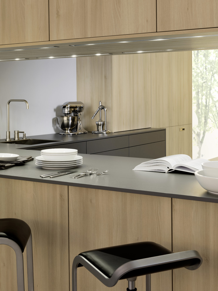 Immagine di una cucina contemporanea di medie dimensioni con lavello sottopiano, ante lisce, ante in legno bruno, top in quarzo composito e elettrodomestici in acciaio inossidabile