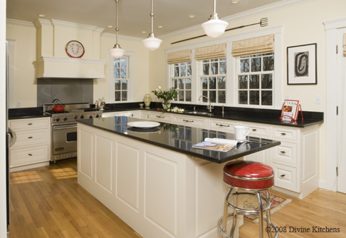 Example of a large u-shaped light wood floor eat-in kitchen design in Boston with an undermount sink, granite countertops, stainless steel appliances and an island